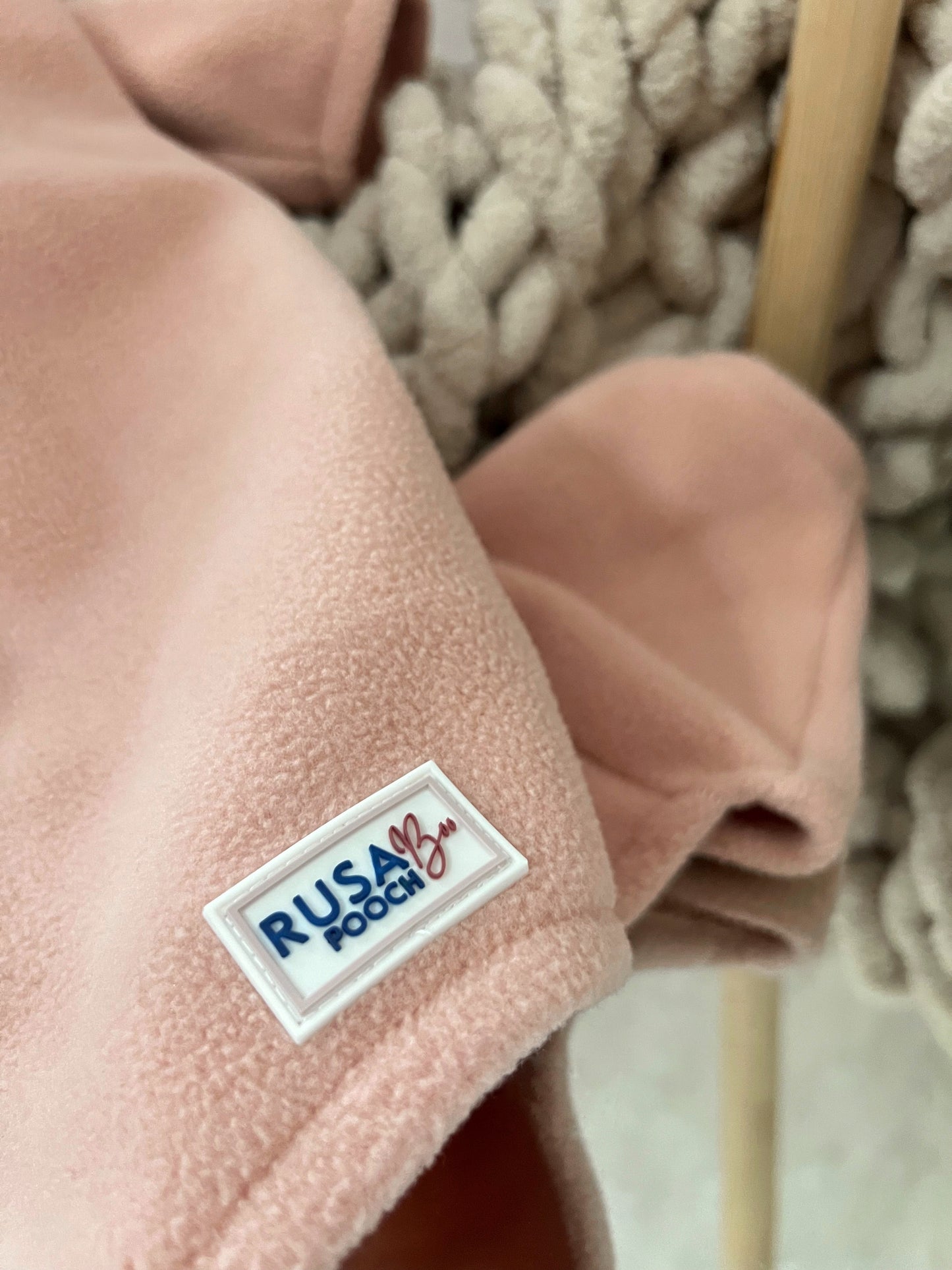 Close up of our branding tag on our peach 4 leg fleece suit
