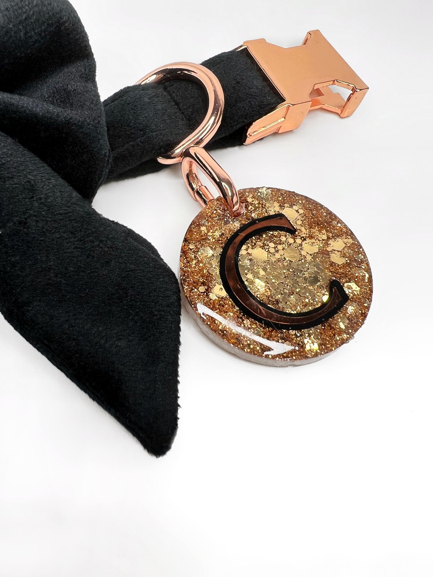 Close up of gold glitter tag on a black velvet collar