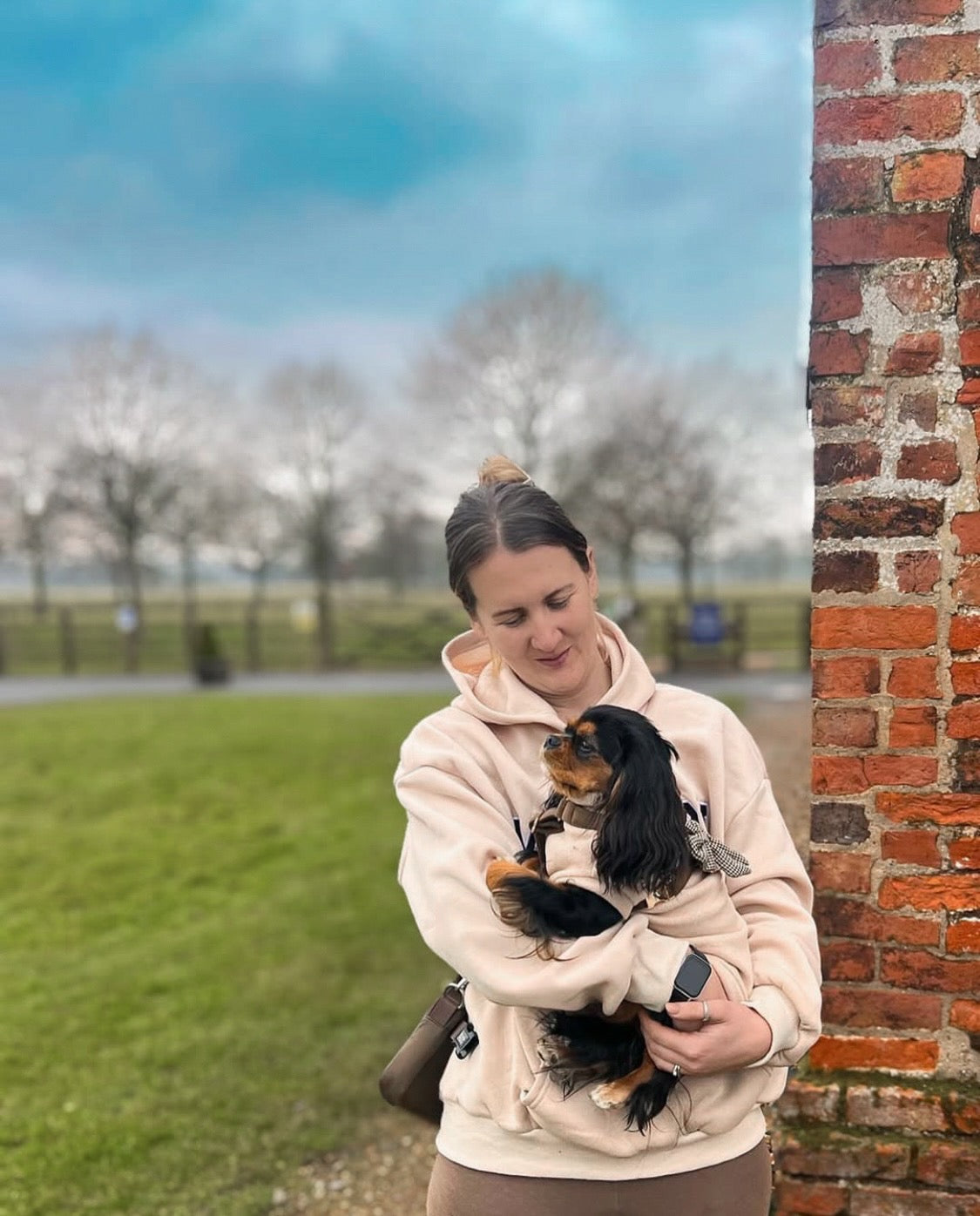 Mum holding cavalier wearing matching beige polar fleece