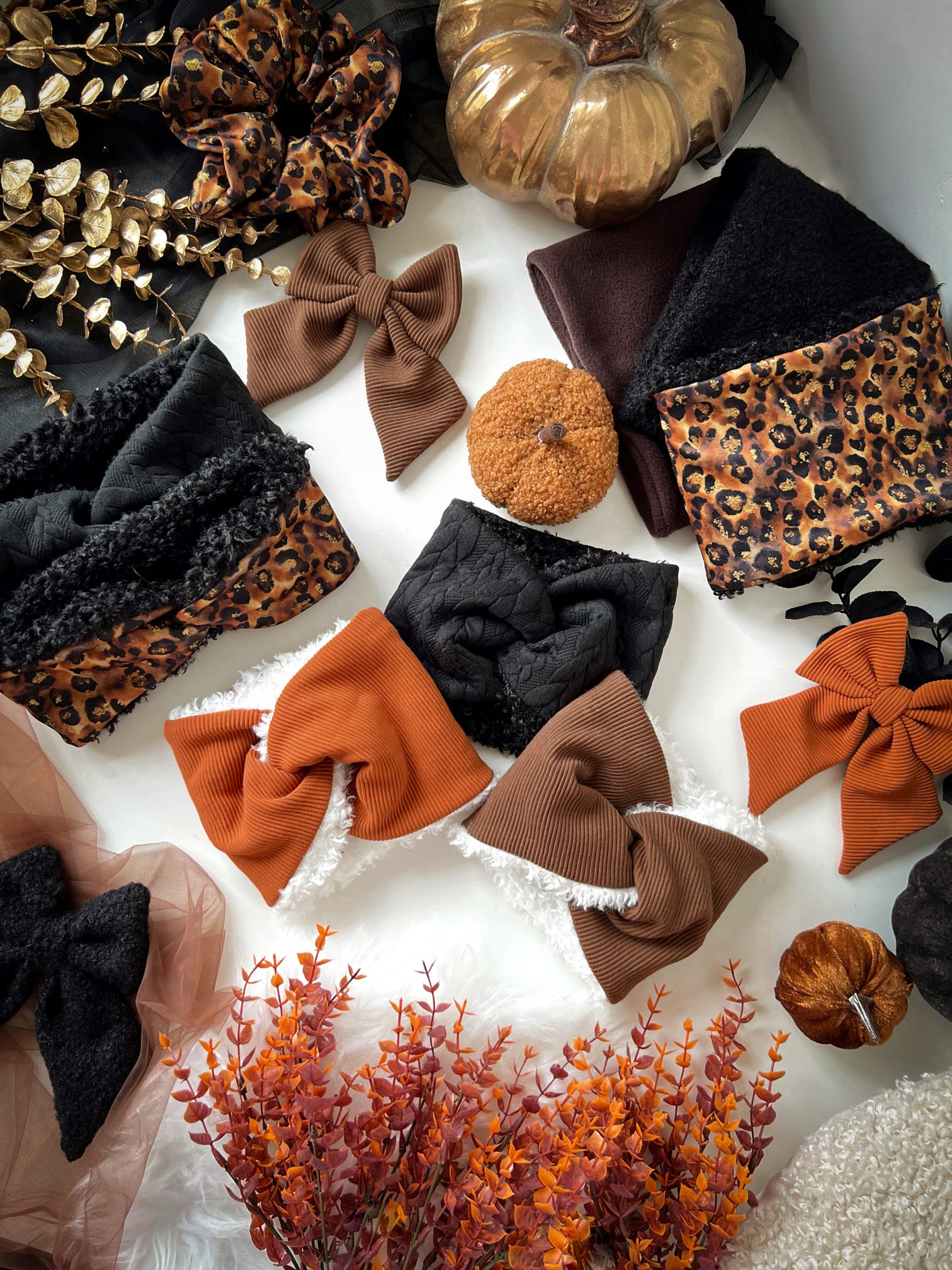 Collection of decorative bows, snoods, headbands and autumn-themed items on a white surface