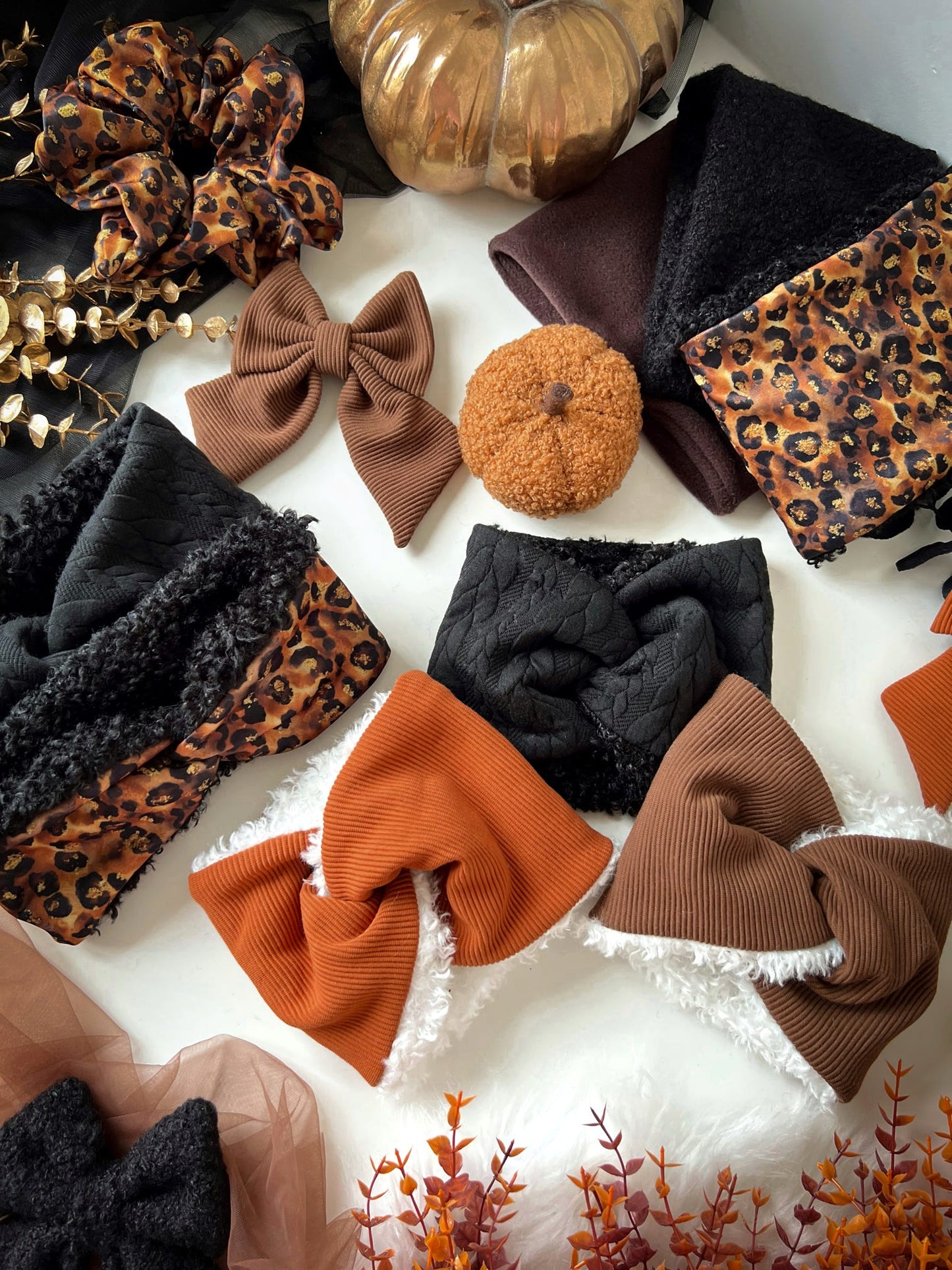 Collection of accessories including bows, headbands and snoods on a white background with autumn-themed decorations.
