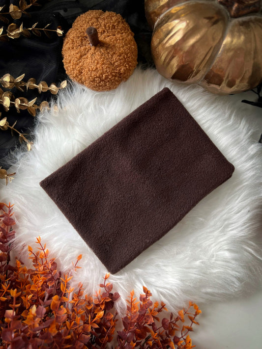 Brown polar fleece dog snood on a white fur surface with decorative pumpkins and gold leaves.